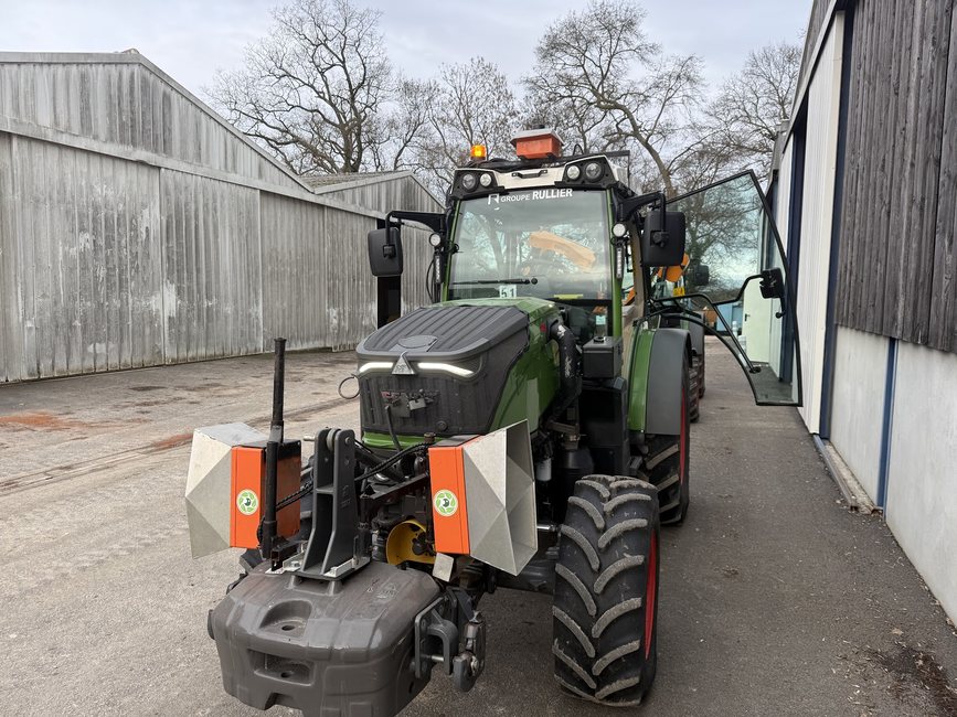 A green Fendt vineyard tractor with Cropsy scanner units on its front frame in a shed alley